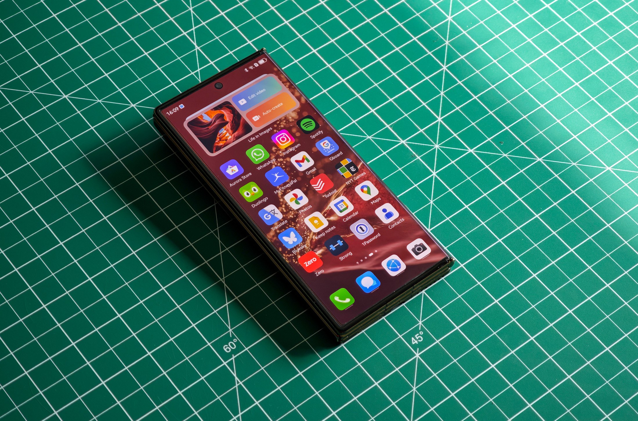 Huawei Mate XT Flat على طاولة خضراء مطوية.