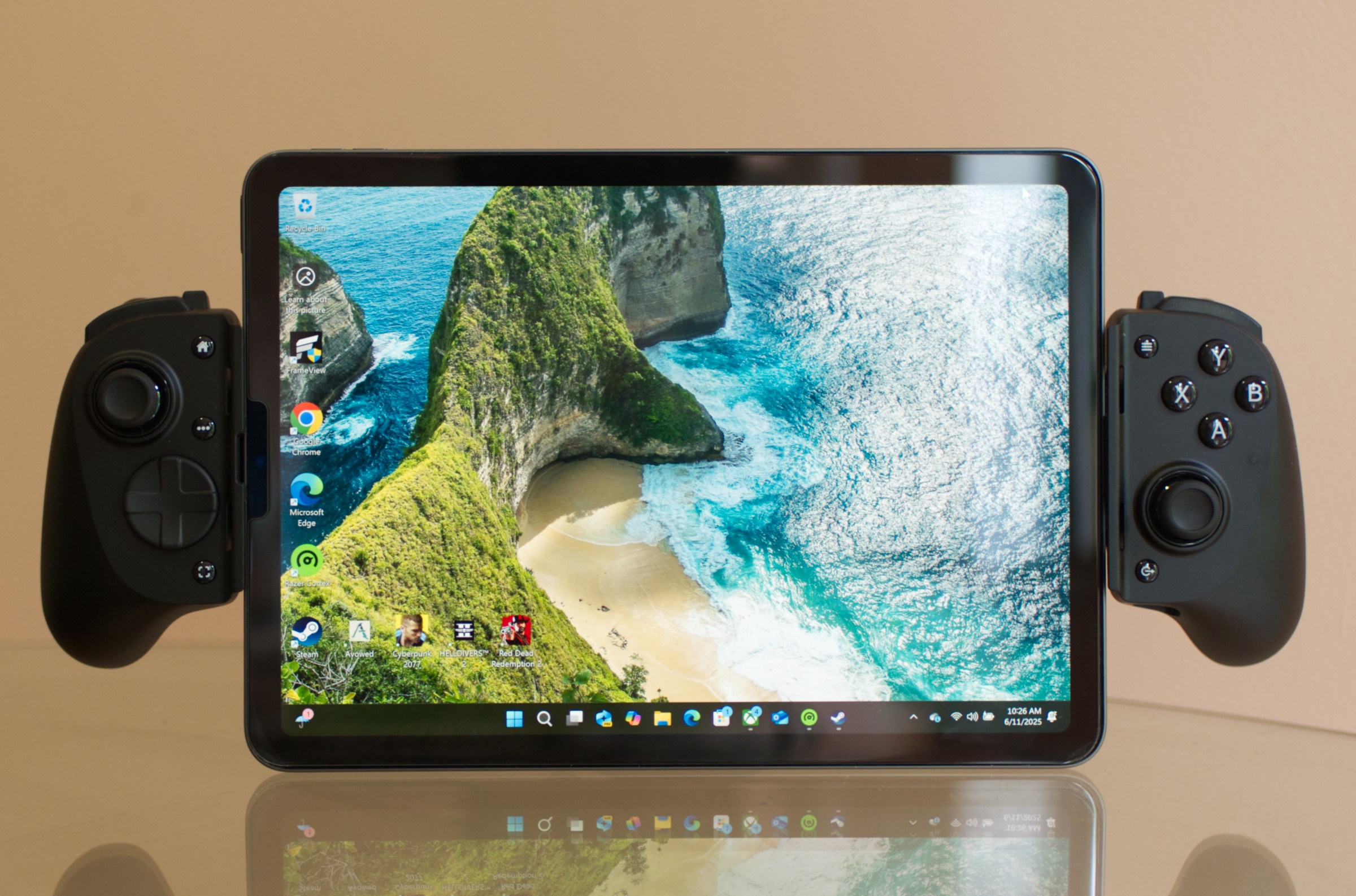 صورة توضح الهواء iPad مزود بوحدة تحكم لعبة Razer Kishi V3 Pro XL. يعرض iPad شاشة Homescreen Windows 11.
